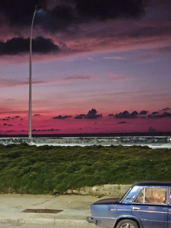 Lada auf dem Malecón im Sonnenuntergang